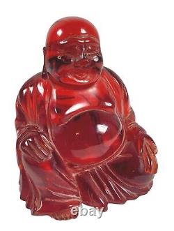 Bouddha rouge en ambre souriant/riant avec support. Environ 3-11/16 H x 3 1/2 L.