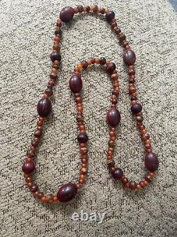 Collier de perles d'ambre antique vintage rouge et orange. Brille sous UV