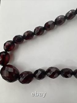 Collier de perles facettées en bakélite vintage avec 27 perles ambre cerise graduées.