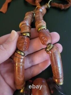 Collier vintage en perles antiques tibétaines avec de grands visages sculptés en pierre de résine d'ambre